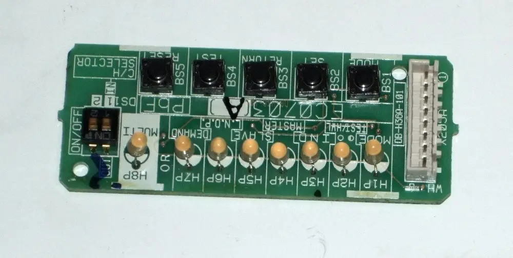 Grüne Serviceplatine mit mehreren Tasten und LEDs, kennzeichnet von Daikin, zur Verwendung in Heizsystemen. Anschlussstecker und Benutzersteuerung sind sichtbar.